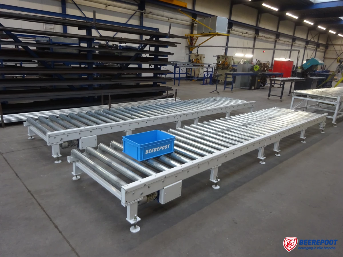 Je ziet twee grijze rollenbanen van Beerepoot netjes naast elkaar in beeld en erachter nog een deel van een derde grijze rollenbanen. Op de achtergrond is voorraad van Beerepoot in beeld omdat de foto genomen is in een voorraadhal van Beerepoot.
