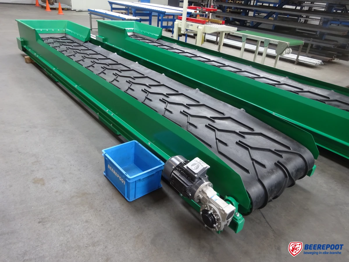 Je ziet twee groene transportbanden van Beerepoot in een voorraadhal van Beerepoot. Voor de eerste transportband staat een blauw kratje van Beerepoot op de grond.
